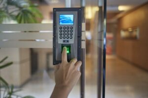 Technician installing biometric fingerprint and facial recognition access control system at a commercial building in Kenya