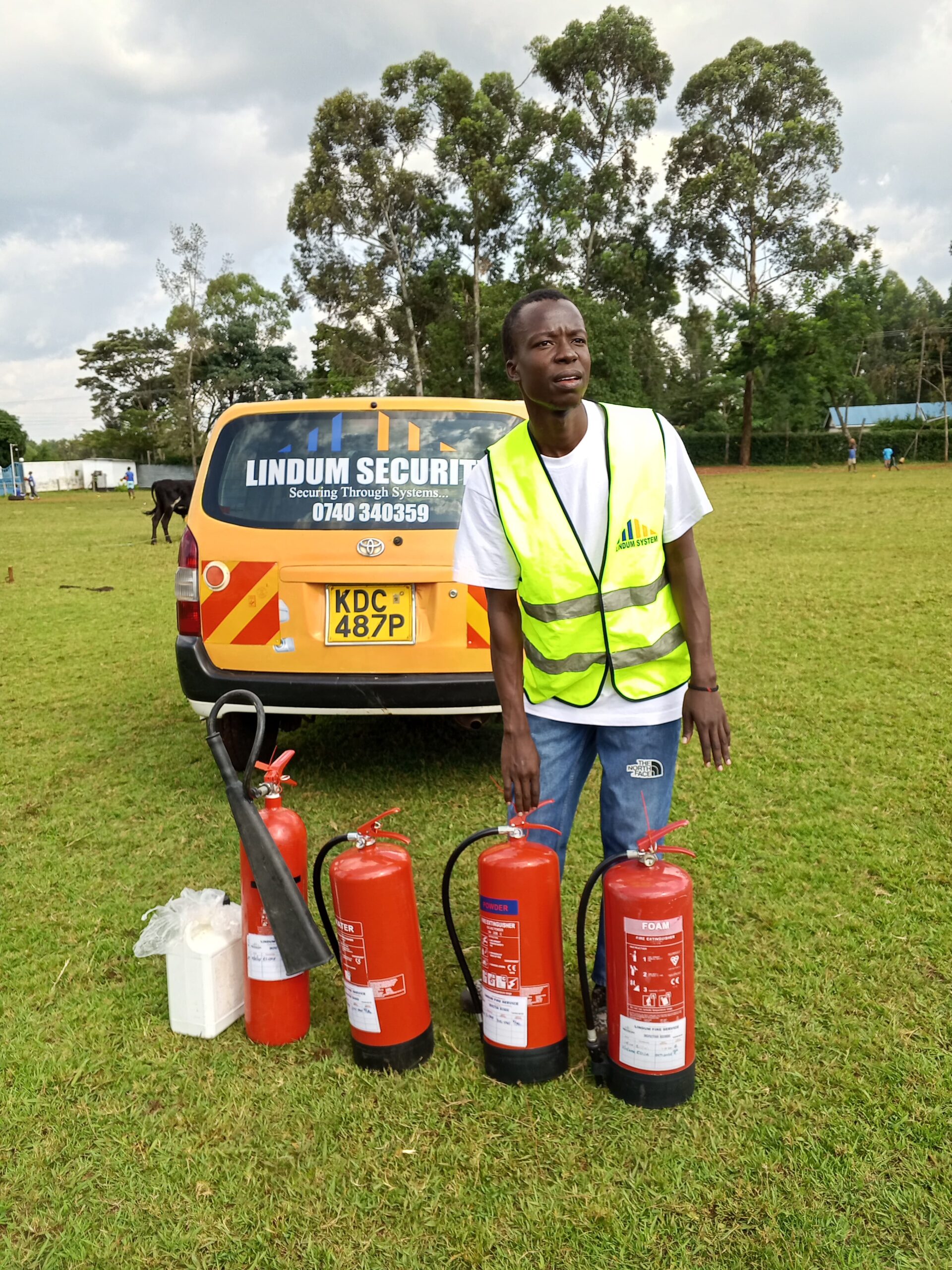 Lindum Systems technician unloading fire extinguishers during safety training setup in Kenya